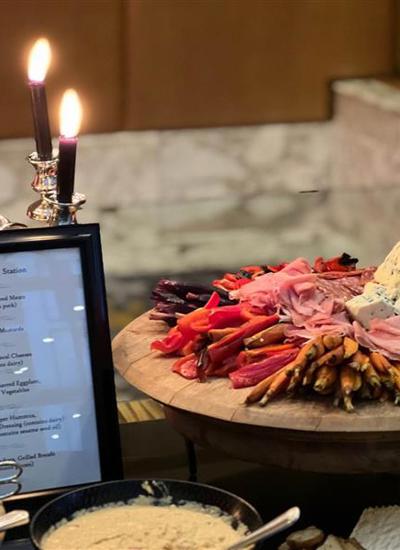 A table with a menu and a candelabra and some food