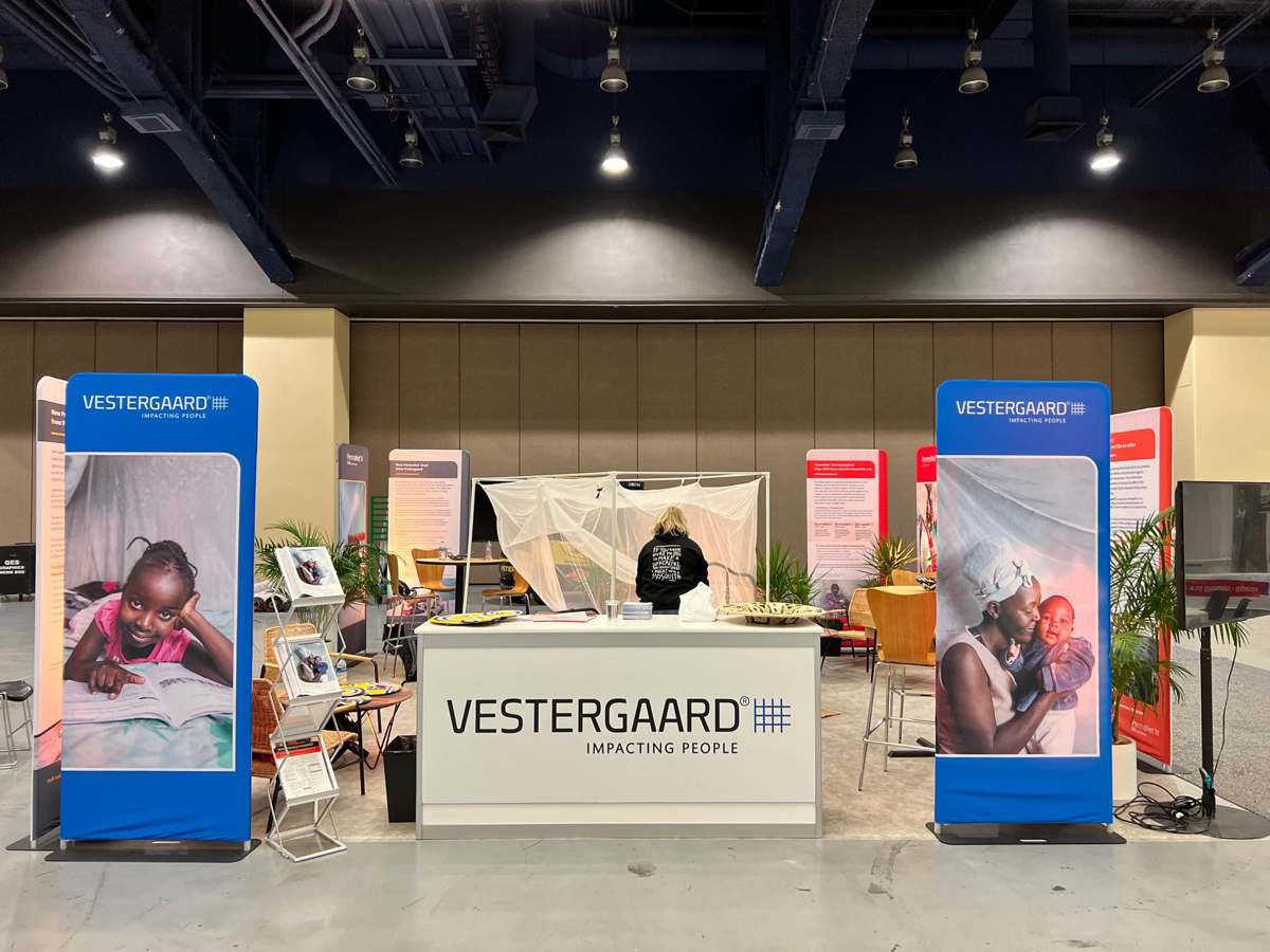 A tradeshow stand featuring the Vestergaard brand and mosquito nets