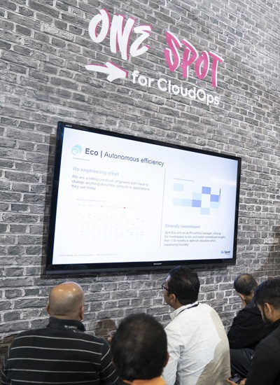 A group of people looking at a TV screen at a tradeshow