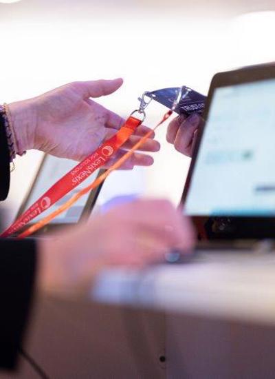 A person handing a delegate their badge at registration